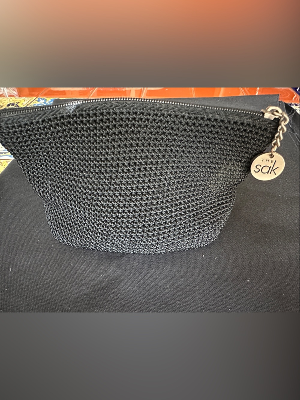 The Sak Black Crochet Zip Pouch with Round Logo Charm